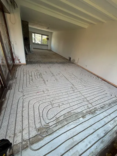 Heizrohre in gefrästen Estrichkanälen im Wohnraum vor dem Verschließen